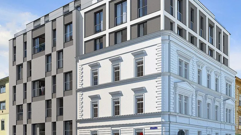 Modernes Gebäude mit klassischer Fassade und zeitgenössischem Anbau an einer Straßenecke.