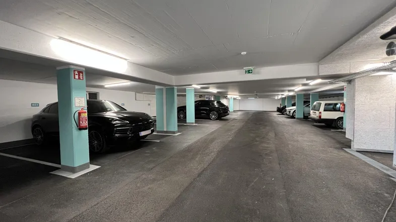 Geräumige Tiefgarage mit mehreren Stellplätzen, guter Beleuchtung und klaren Markierungen.