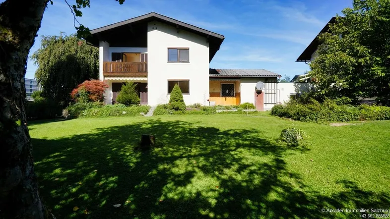 Großzügiger Gartenbereich mit Rasenfläche und altem Baumbestand vor dem Einfamilienhaus.