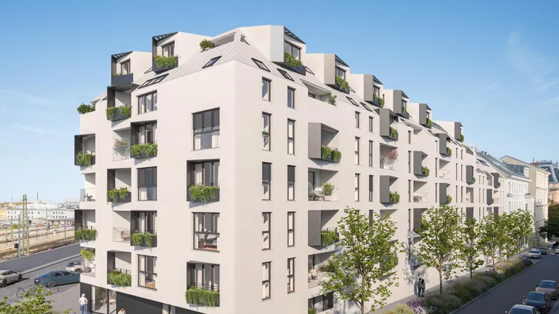 Moderne Wohnanlage mit weißer Fassade, zahlreichen Balkonen und begrünten Außenbereichen in urbaner Umgebung.