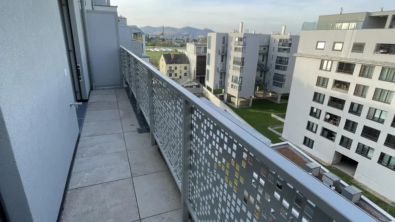 Geräumiger Balkon mit Fliesenboden und modernem Geländer, bietet einen weiten Blick auf die Umgebung.