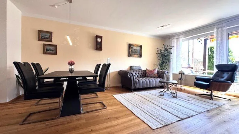 Heller Wohn-Essbereich mit Parkettboden, beiger Wandfarbe und gemütlicher Sitzecke.