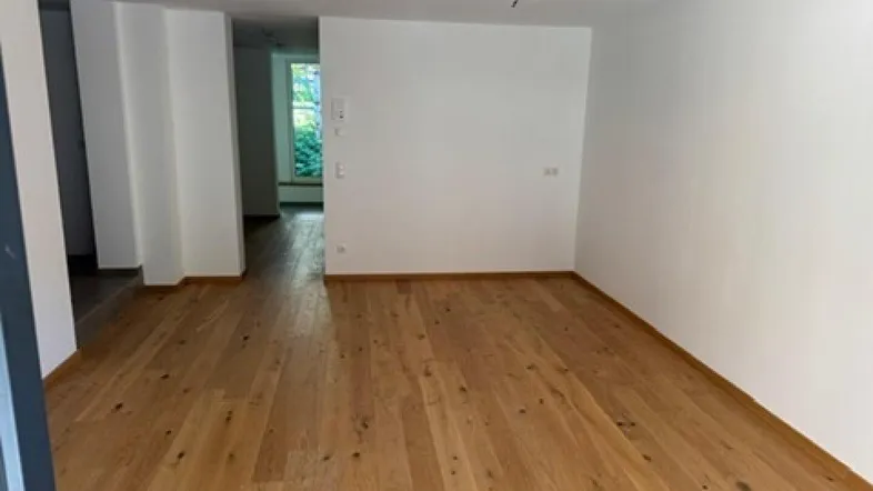 Heller Raum mit Holzboden und weißen Wänden, bereit zur individuellen Gestaltung und Nutzung.