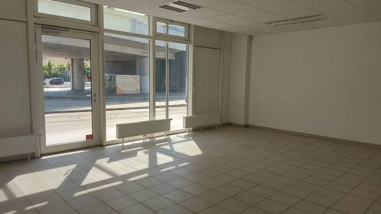 Heller, leerer Geschäftsraum mit großen Schaufenstern und Fliesenboden, ideal für verschiedene Nutzungskonzepte.