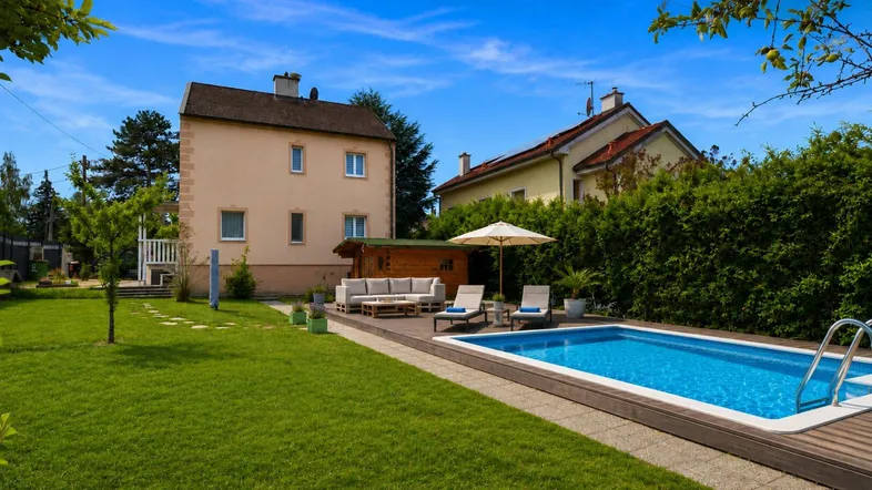 Großer Garten mit Pool, Holzdeck und gemütlicher Lounge-Ecke vor dem Haus.