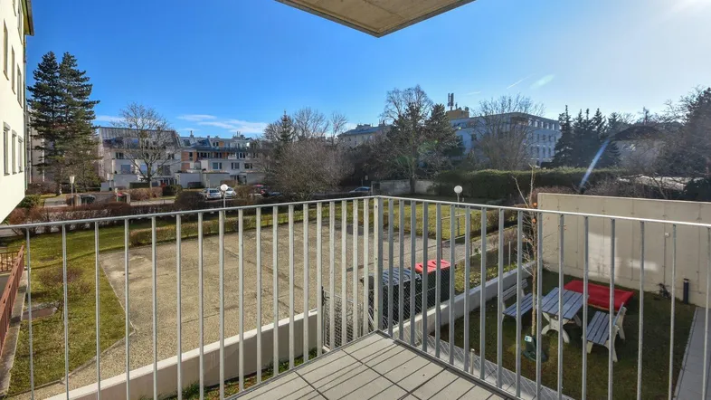 Heller Balkon mit Blick auf die umliegende Wohngegend und Grünflächen.