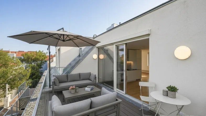 Geräumige Dachterrasse mit bequemen Loungemöbeln und Sonnenschirm, ideal zum Entspannen im Freien.