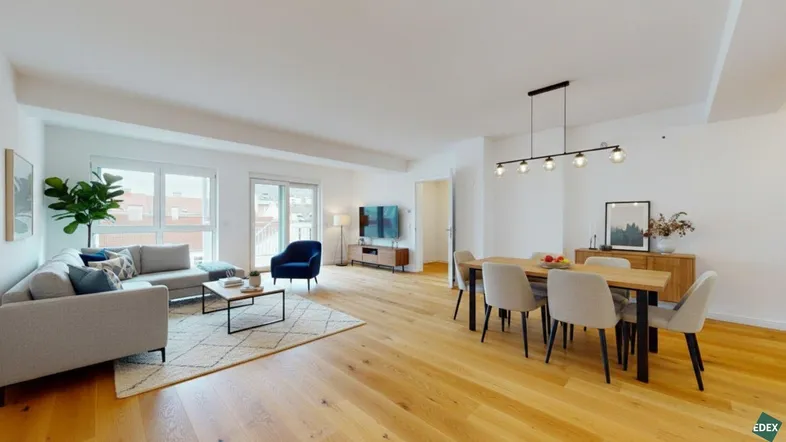 Heller, offener Wohn-Essbereich mit Holzboden, modernen Möbeln und Zugang zum Balkon.