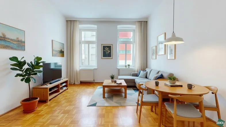 Helles Wohn- und Esszimmer mit Parkettboden, bequemer Sitzecke und Esstisch für gesellige Stunden.