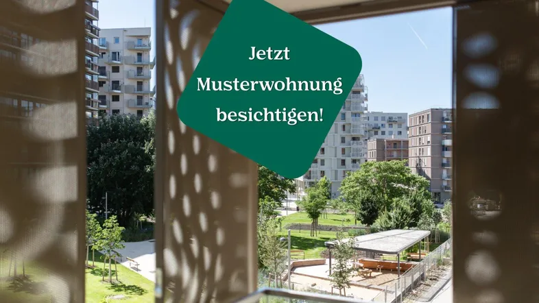 Blick von einem Balkon auf eine moderne Wohnanlage mit Grünflächen und Spielplatz.