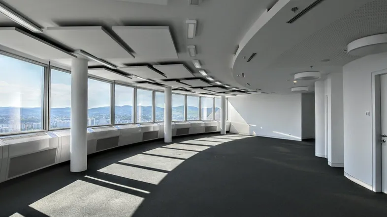 Geräumiges, modernes Büro mit großen Fenstern, die einen weiten Blick über die Stadt bieten.