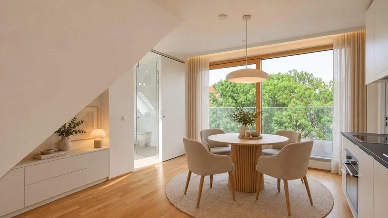 Heller Essbereich mit Holzboden, großen Fenstern und Zugang zu einem Balkon, mit Blick ins Grüne.