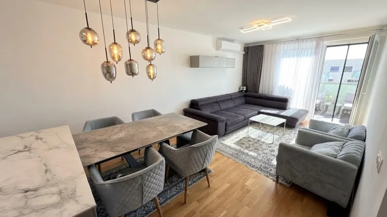 Heller Wohn- und Essbereich mit modernem Design, Holzboden und Zugang zum Balkon.