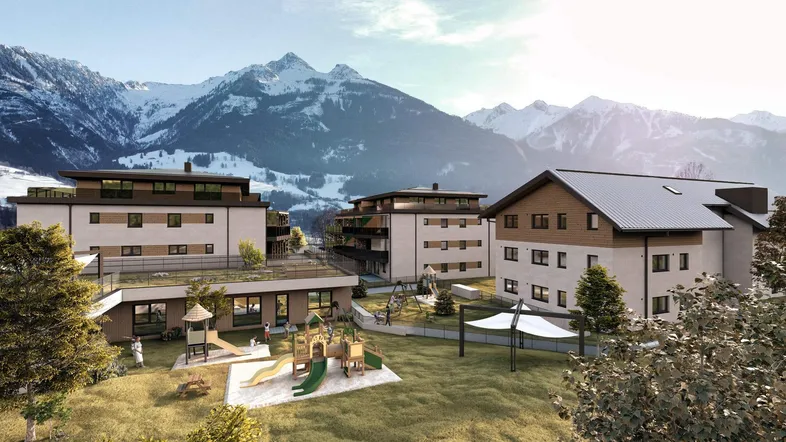 Moderne Wohngebäude mit Spielplatz und Bergblick in einer idyllischen alpinen Umgebung.