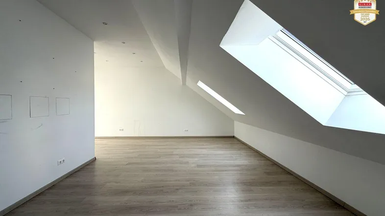 Heller Dachbodenraum mit Laminatboden und Dachfenstern, bereit für den individuellen Ausbau.