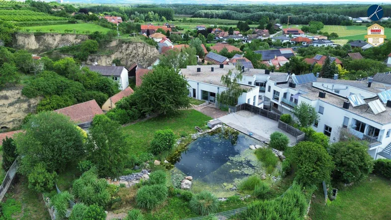 Luftaufnahme des Anwesens mit einem großen Naturteich, umgeben von üppigem Grün und ländlicher Umgebung.