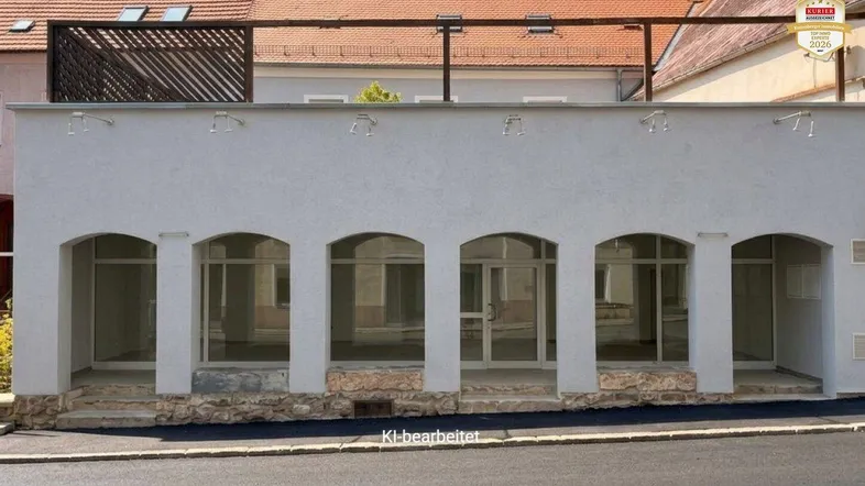 Moderne Geschäftsfassade mit großen Bogenfenstern und einer Dachterrasse im Hintergrund.
