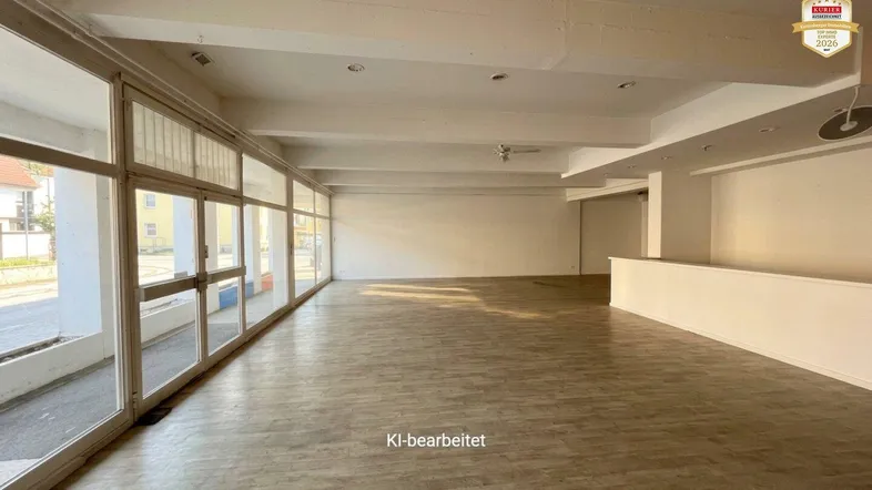 Geräumiger, leerer Gewerberaum mit großen Fenstern und hellem Laminatboden, ideal für verschiedene Nutzungen.