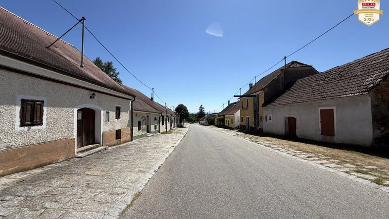 Blick auf eine ländliche Straße mit traditionellen Häusern unter blauem Himmel.