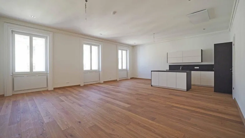 Geräumiger offener Wohnbereich mit moderner Küchenzeile, Kochinsel und elegantem Parkettboden.