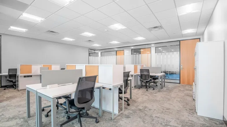 Großes, modernes Großraumbüro mit flexiblen Arbeitsplätzen, Teppichboden und abgehängter Decke.