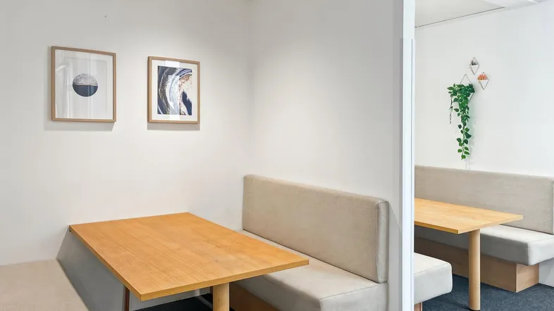 Gemütliche Büronischen mit Holztischen und gepolsterten Sitzbänken, ideal für konzentriertes Arbeiten oder kleine Besprechungen.