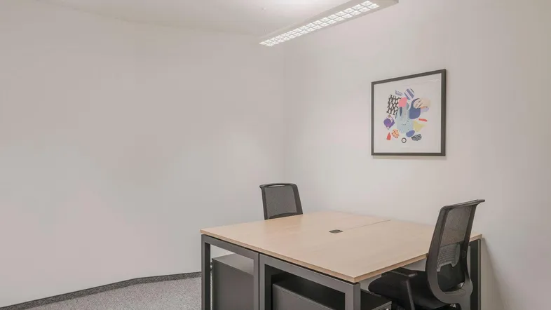 Modernes Büro mit Schreibtisch für zwei Personen, Teppichboden und minimalistischer Wandkunst.