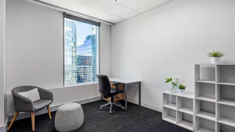 Modernes Einzelbüro mit Schreibtisch, Stuhl und Blick auf die Stadt durch ein großes Fenster.