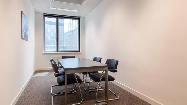 Kleiner Besprechungsraum mit einem Tisch und vier Stühlen, ideal für private Meetings oder konzentriertes Arbeiten.