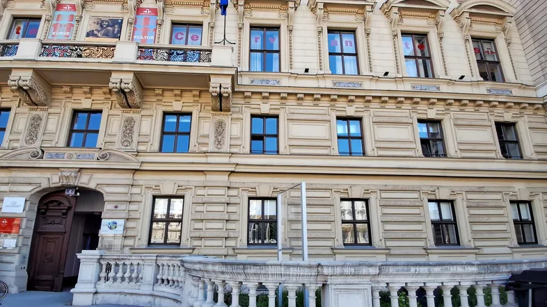 Historische Fassade eines Gebäudes mit vielen Fenstern und dekorativen Elementen, die eine gehobene Ausstattung andeuten.