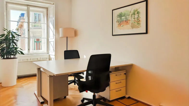 Helles Büro mit Holzboden, großem Fenster und modernem Schreibtisch, ideal für konzentriertes Arbeiten.