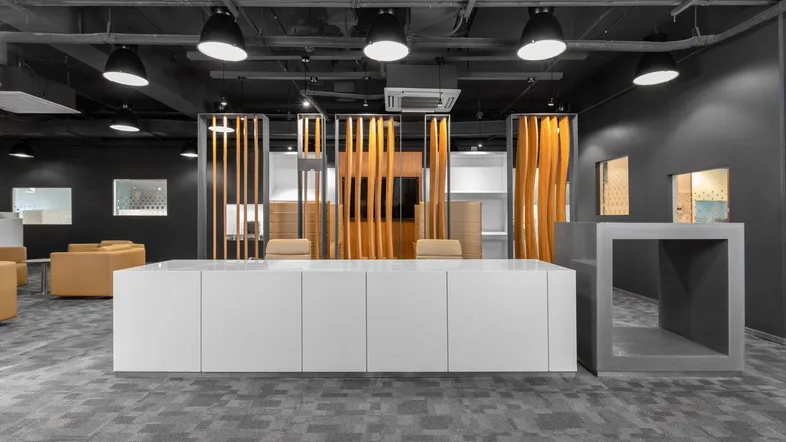 Moderner Bürobereich mit dunkler Decke, Teppichboden und stilvollen Holzlamellen als Raumteiler.