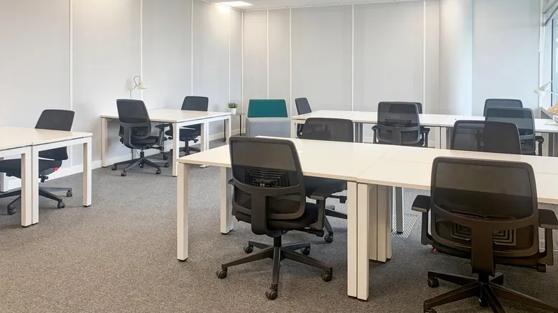 Heller, moderner Großraumbüro mit mehreren Arbeitsplätzen und Teppichboden für eine produktive Arbeitsumgebung.