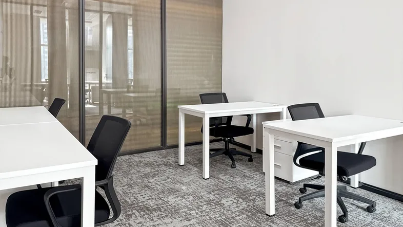 Helles Büro mit modernen weißen Schreibtischen, ergonomischen Stühlen und gemustertem Teppichboden.