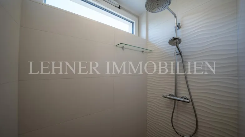 Moderne Duschkabine mit Regendusche und Fenster für natürliche Belüftung und Helligkeit.
