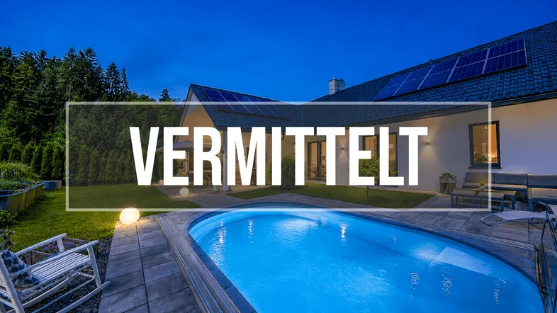 Modernes Haus mit beleuchtetem Pool, Terrasse und Solaranlage im Garten bei Nacht.