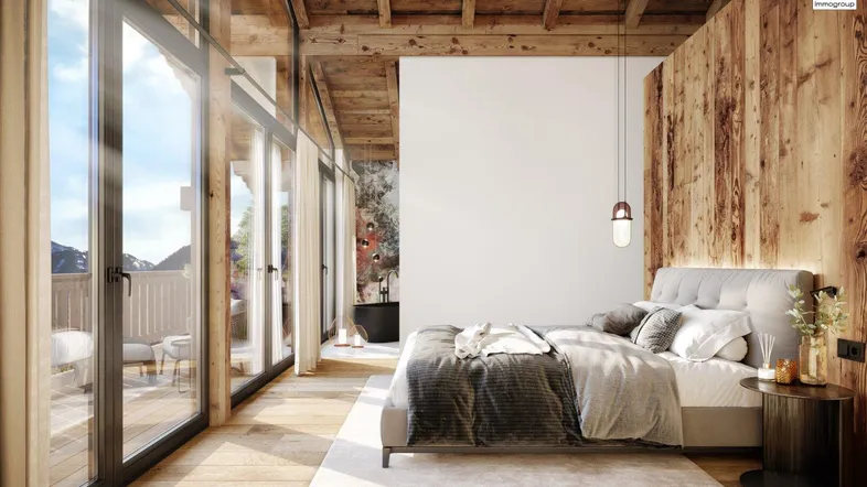 Helles Schlafzimmer im modernen Chalet-Stil mit Holzelementen, Bergblick und Zugang zum Balkon.