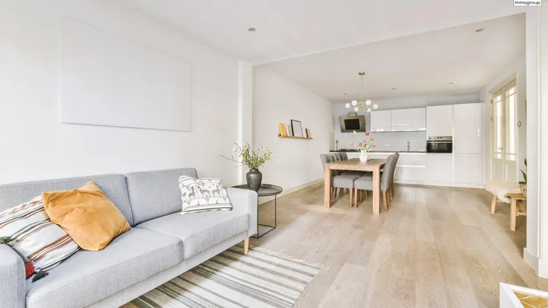 Helles, offenes Wohn-Esszimmer mit moderner Küche, Parkettboden und viel Tageslicht.