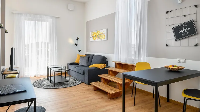 Helles Wohn- und Esszimmer mit modernem Design, Laminatboden und Zugang zu großen Fenstern.