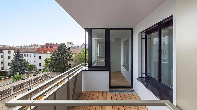 Moderner Balkon mit Holzboden und Blick über die Stadt, ideal für entspannte Stunden im Freien.