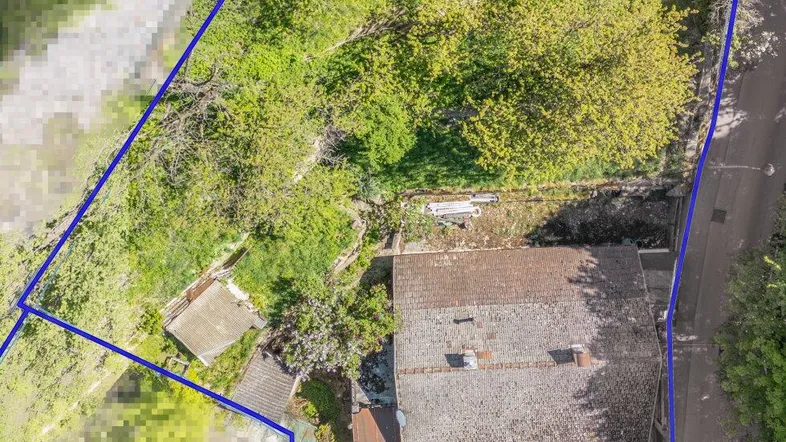 Luftaufnahme des Grundstücks mit Haus und Garten, umrandet von blauen Linien.
