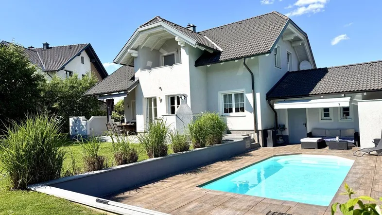 Großzügiger Gartenbereich mit privatem Pool und gepflegter Rasenfläche hinter dem modernen Einfamilienhaus.