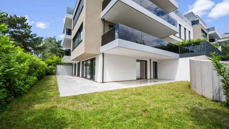Moderne Wohnanlage mit großzügiger Terrasse und Gartenbereich im Erdgeschoss.