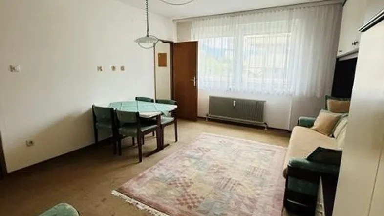 Helles Wohn- und Esszimmer mit Teppichboden, Esstisch und Sofa, gut gepflegt.