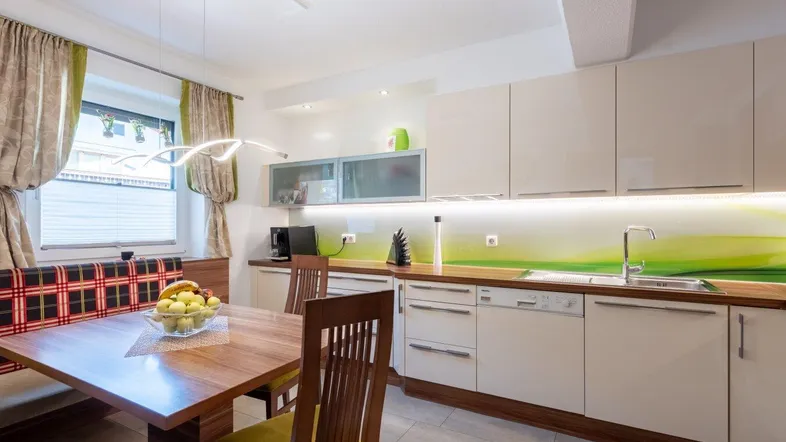 Moderne Einbauküche mit hellem Design, Essbereich und Blick ins Grüne.