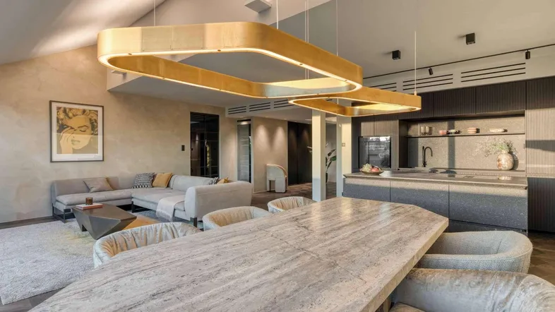 Modernes offenes Wohnzimmer mit Essbereich, Küche und hohen Decken.