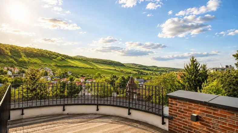 Große Holzterrasse mit Panoramablick auf die umliegende Hügellandschaft und Weinberge unter blauem Himmel.