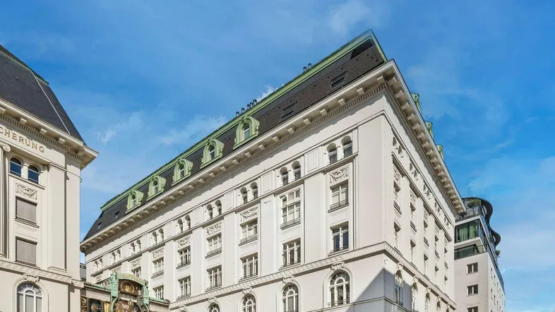 Historisches Gebäude mit aufwendiger Fassade und Mansarddach in der Stadt.