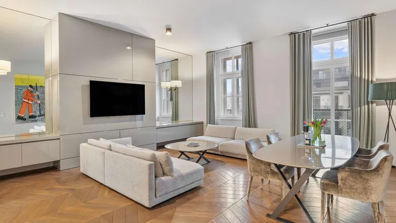 Helles, modernes Wohn-Esszimmer mit Fischgrätparkett, stilvollen Möbeln und integriertem TV-Bereich.
