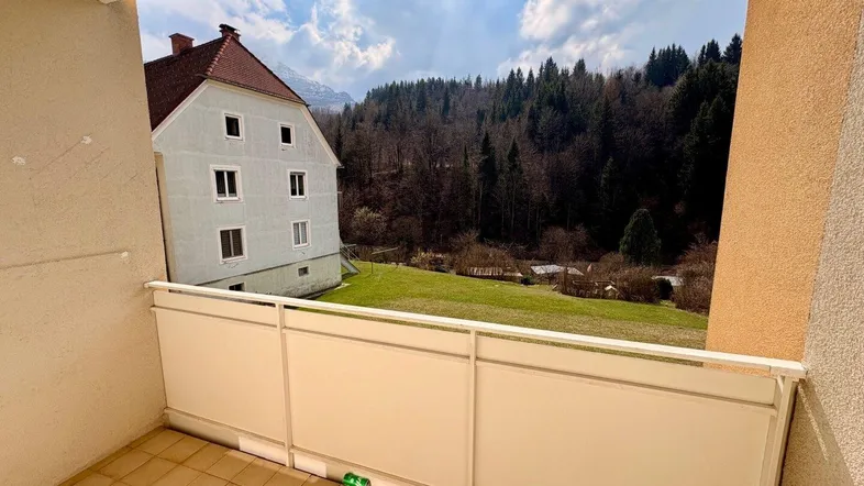 Balkon mit Fliesenboden und weitem Blick auf die umliegende Natur und Berge.